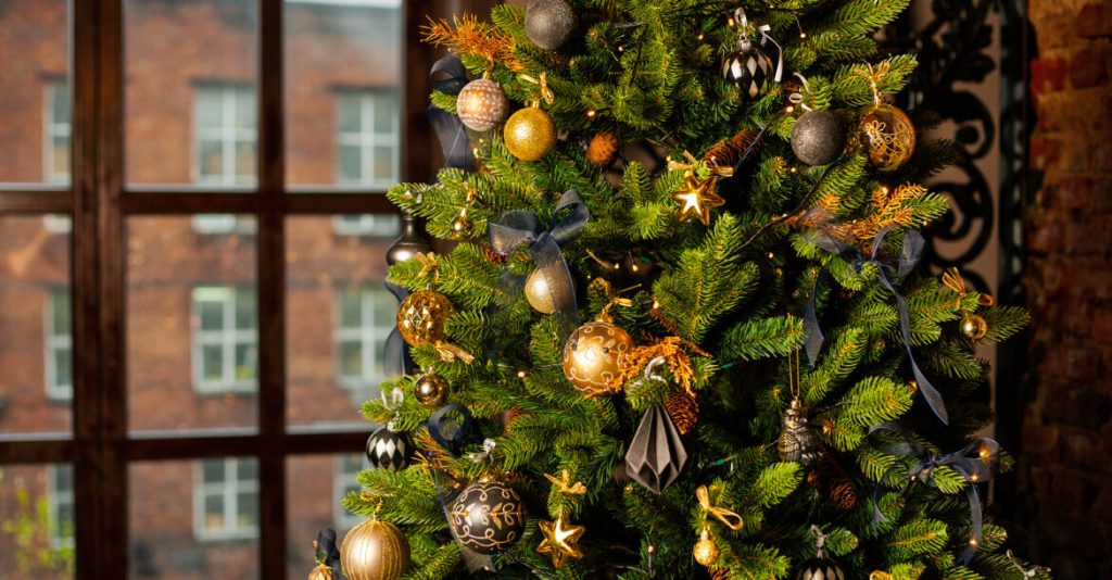 A Christmas Song Seldom Sung close up of a christmas tree decorated with gold balls and blue bows. christmas holiday concept